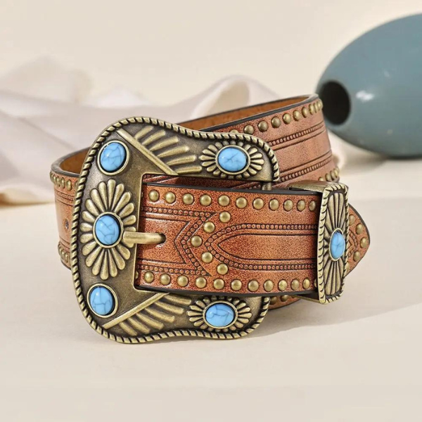 Gros plan sur la ceinture western femme avec gravures et pierres turquoise