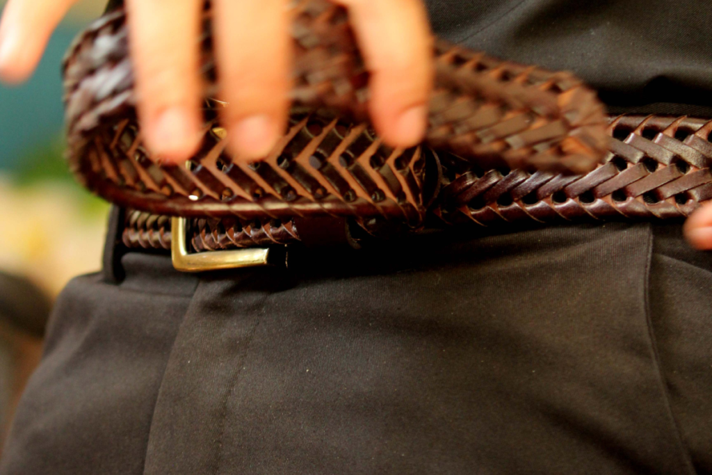 Ceinture tressée en cuir marron sur un pantalon noir, choix idéal pour marquer la taille