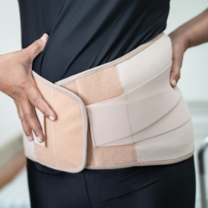 Ceinture lombaire beige portée par une femme pour soulager le mal de dos