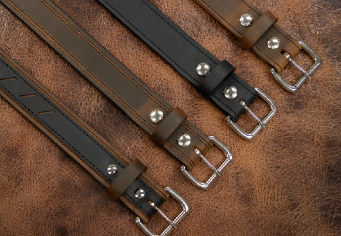 Ensemble de ceintures réversibles pour homme en cuir noir et marron, alignées sur un fond en cuir.